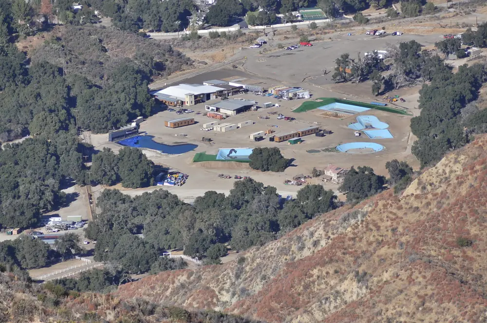 Ranch buildings in a dry canyon seen from a ridge trail above